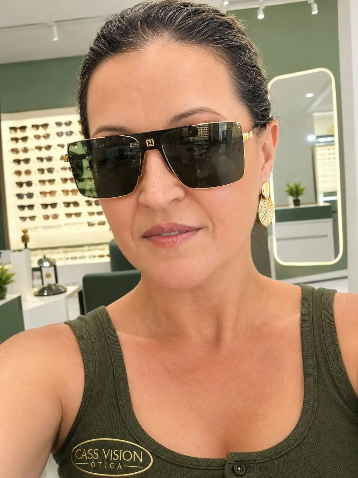 Óculos de sol com lentes escuras e armação dourada